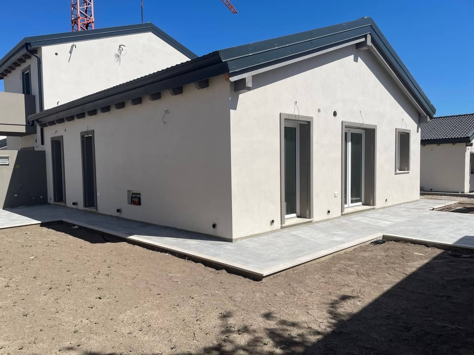 Casa a un piano di nuova costruzione, con tetto a falde, pavimentazione esterna e giardino ancora da sistemare